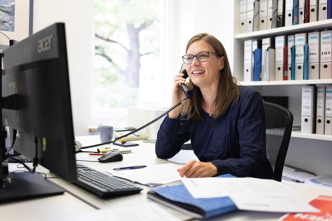 Mitarbeiterin der Kanzlei im Telefongespräch mit einem Mandanten