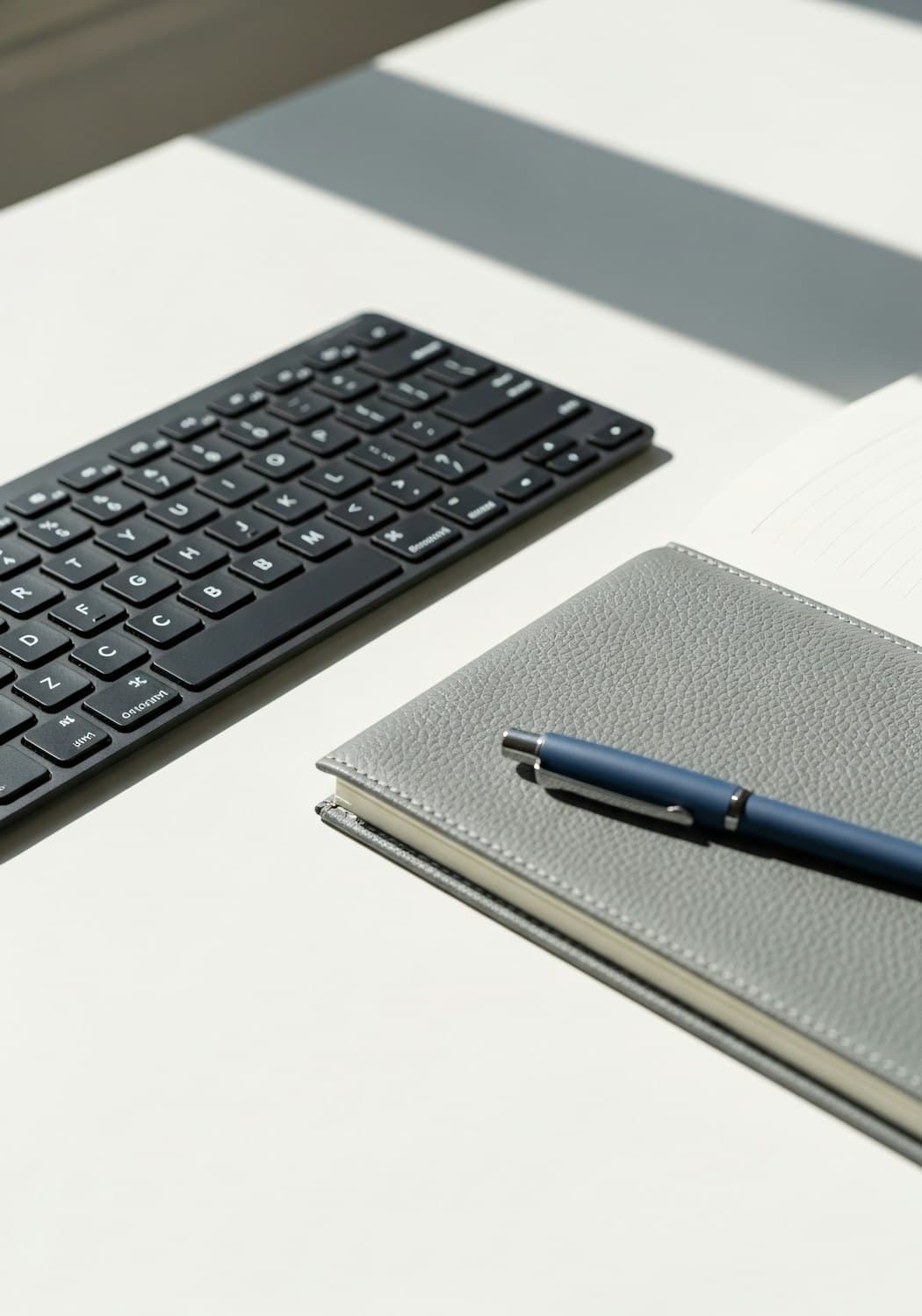 Schreibtisch mit Tastatur, Notizbuch und Stift